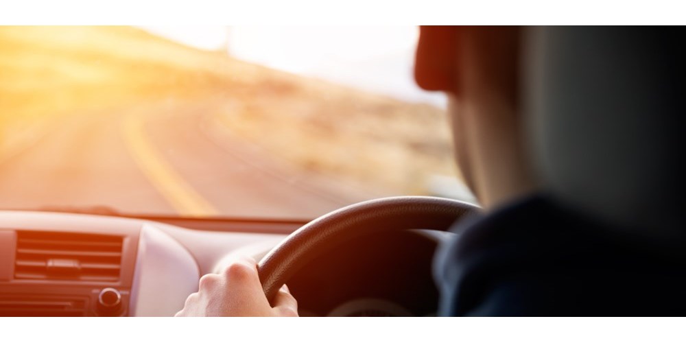 Man driving with sunshine ahead