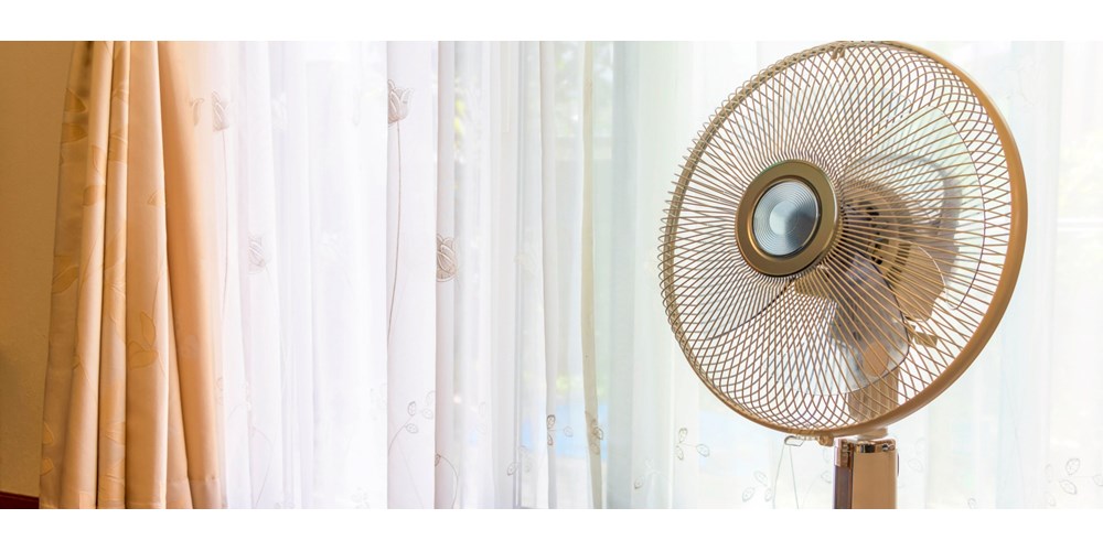 Electric fan in front of curtains