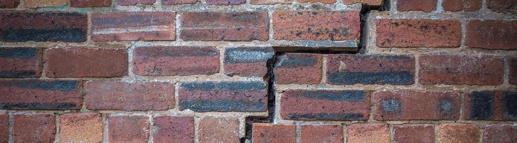 Cracks in red brick wall