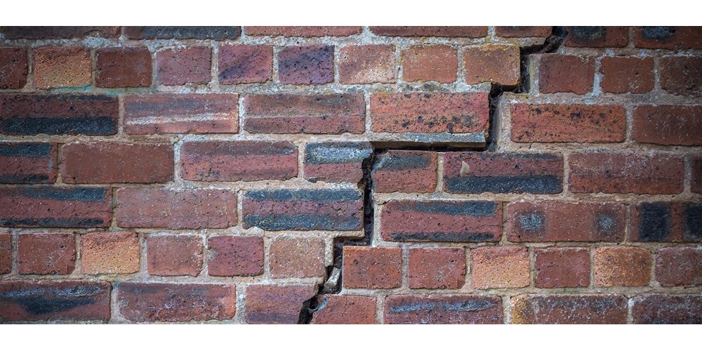 Cracks in red brick wall