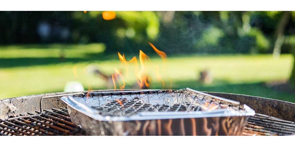 Disposable barbecue alight in garden