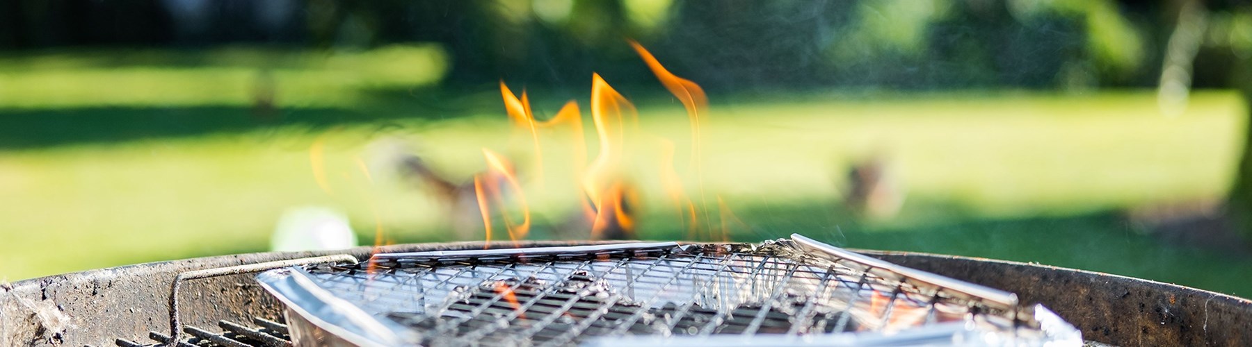 Disposable barbecue alight in garden