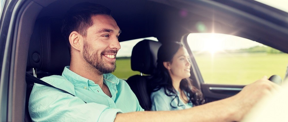 Tips for driving in the heat - smiley man drives car with woman in passenger seat