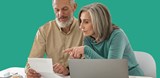 Couple sit at table with paperwork and laptop on green background